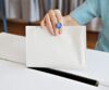 Frau wirft Stimmzettel in Wahlurne