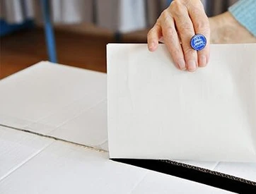 Frau wirft Stimmzettel in Wahlurne