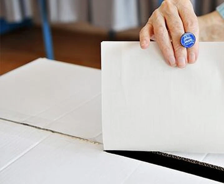 Frau wirft Stimmzettel in Wahlurne